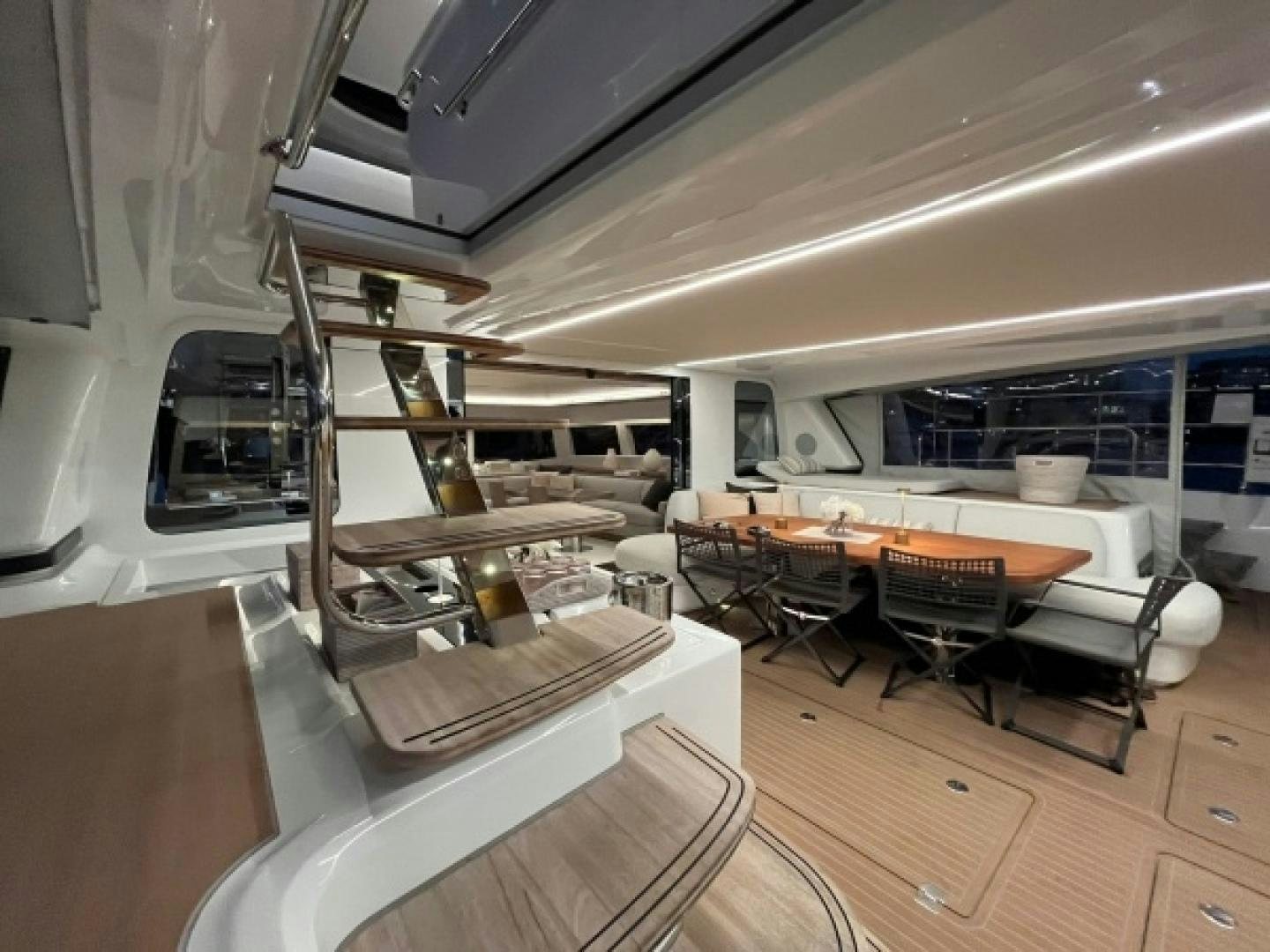 a room with a table chairs and a shelf with objects on it aboard SUNLOVE Yacht for Sale