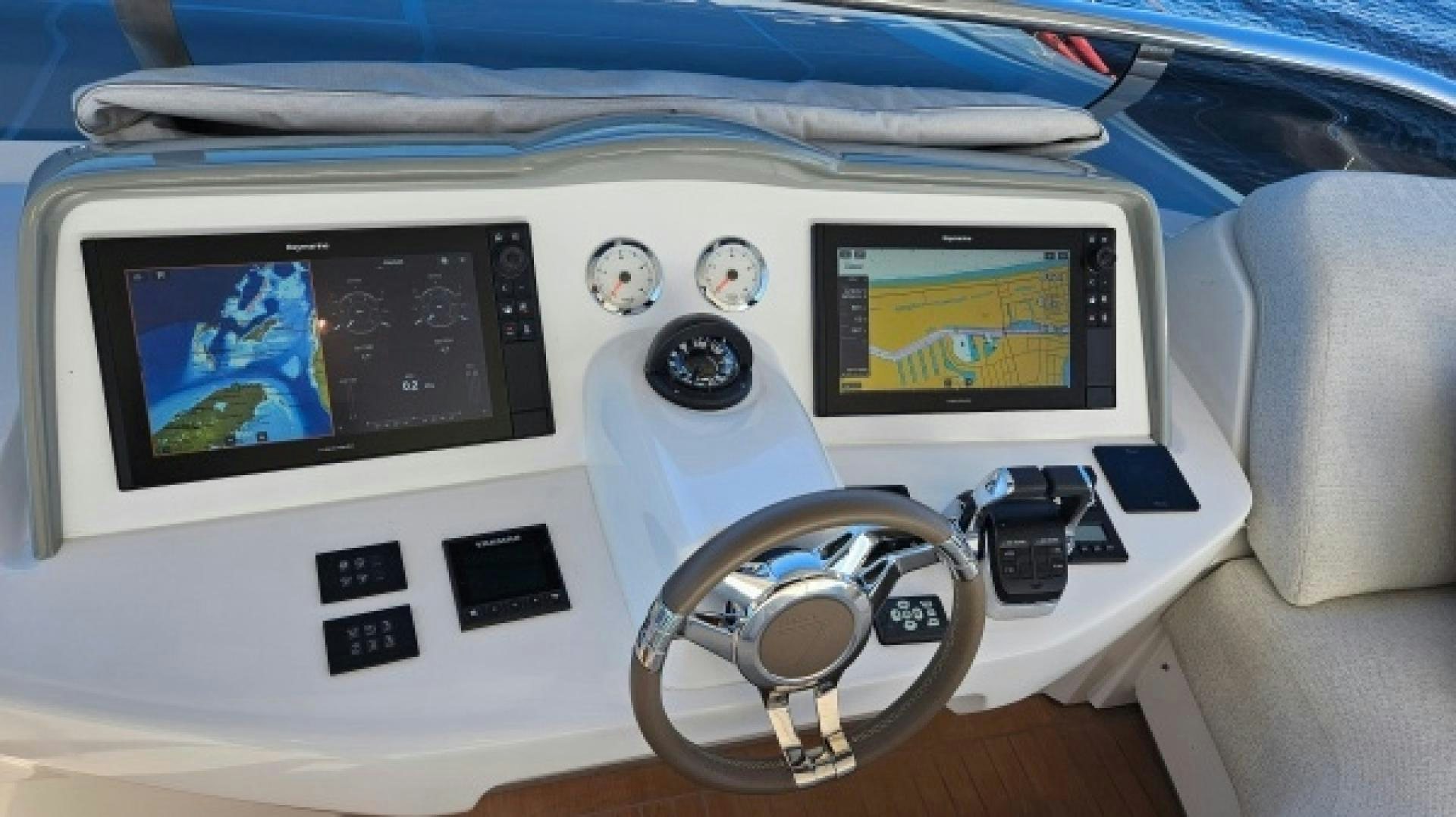 a white console with a screen and buttons and a steering wheel aboard SUNLOVE Yacht for Sale