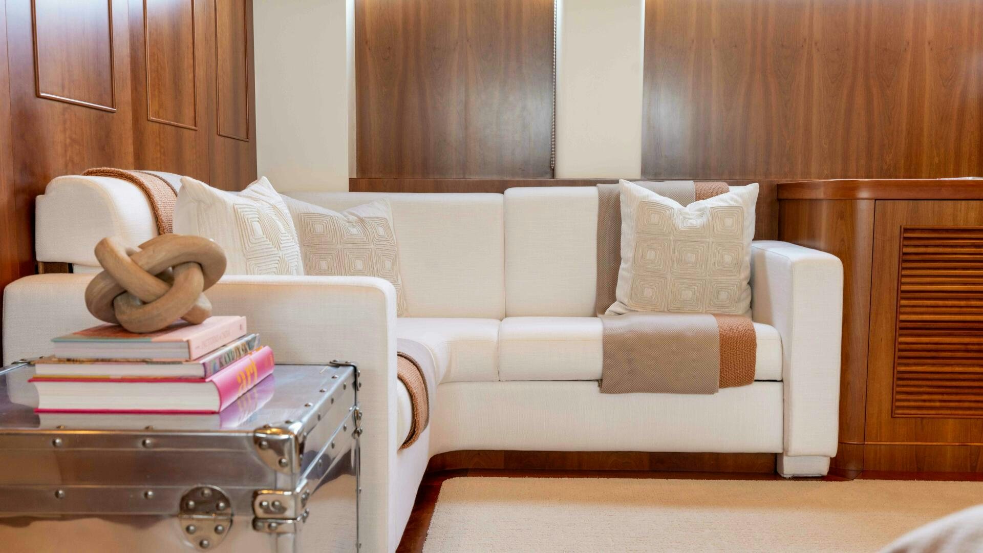 a white couch with a coffee table and books on it aboard STAY SALTY Yacht for Sale