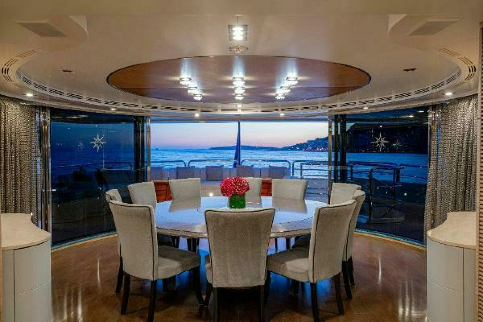 a large room with a table and chairs and a large window aboard JUSTA DELIA Yacht for Sale