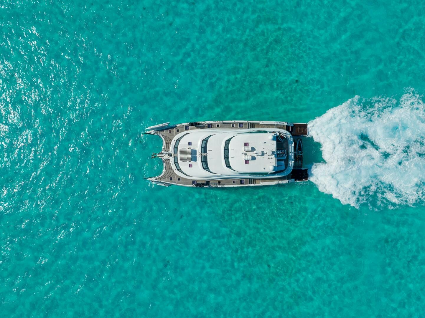a bottle of alcohol on a green lawn aboard ROYAL RITA Yacht for Sale