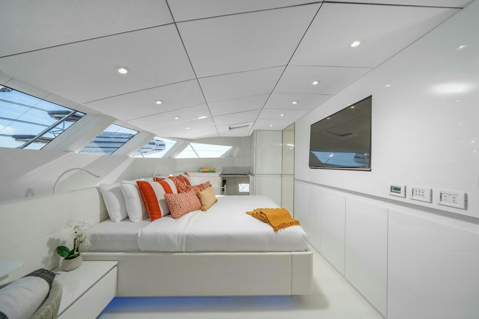 a white room with a white couch and a tv on the wall aboard ROYAL RITA Yacht for Sale