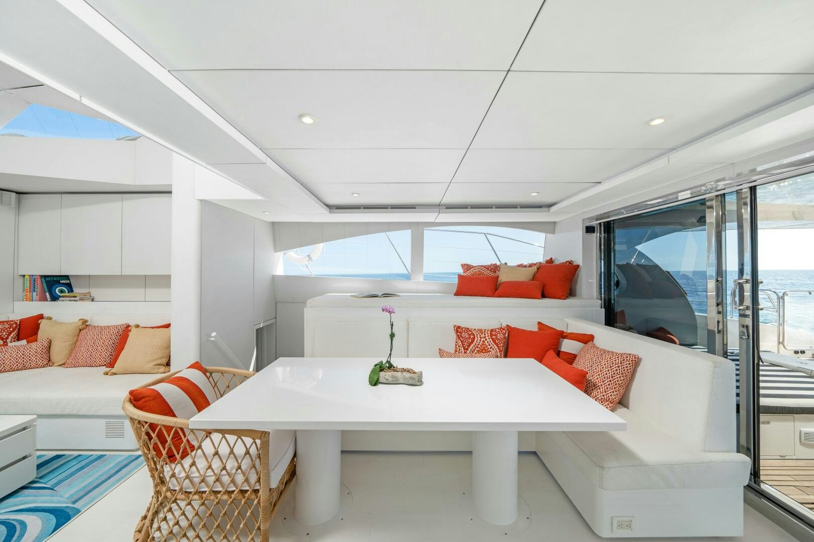 a living room with a white table and red couches aboard ROYAL RITA Yacht for Sale