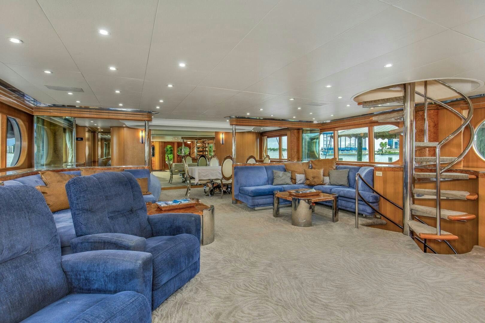 a living room with blue couches aboard BOSS Yacht for Sale