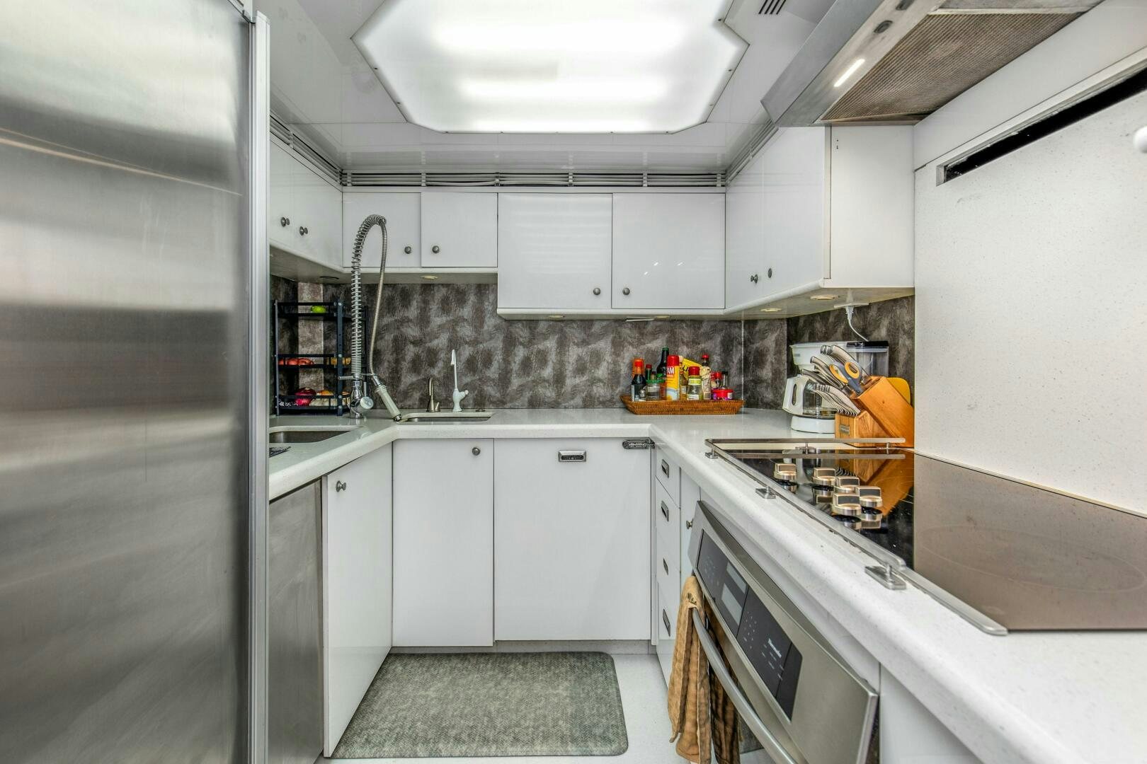 a kitchen with white cabinets aboard BOSS Yacht for Sale