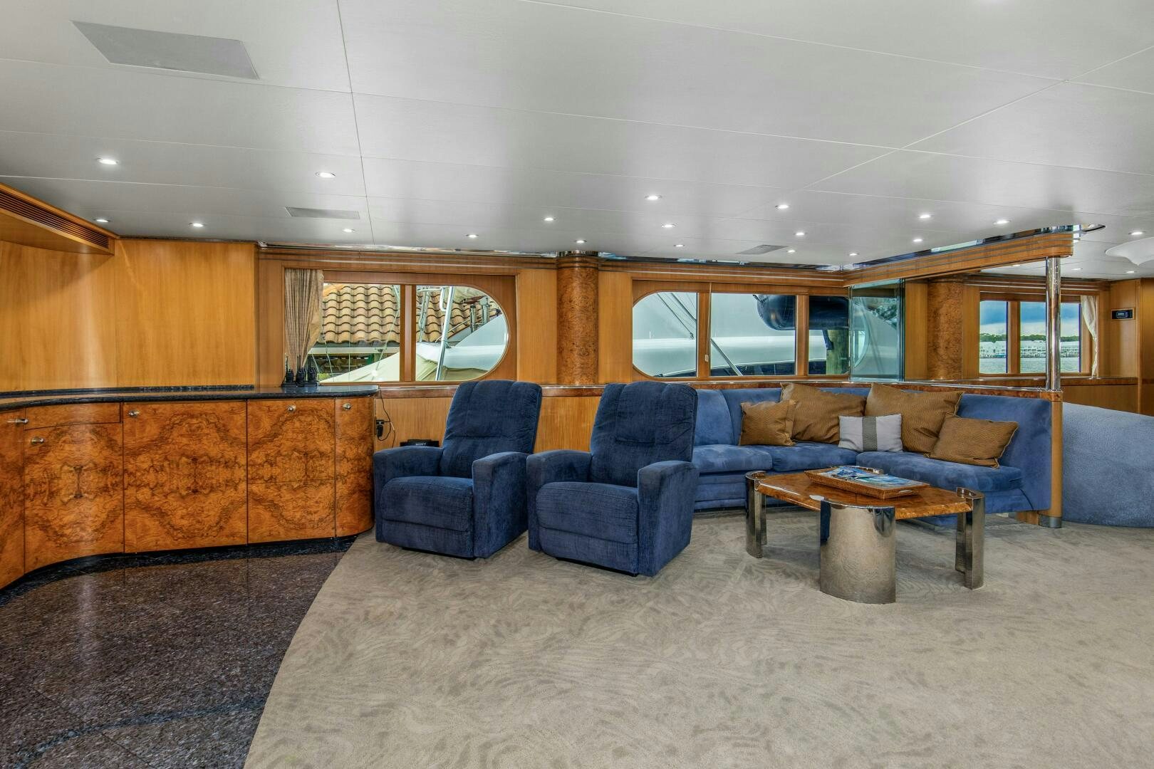 a living room with blue chairs aboard BOSS Yacht for Sale