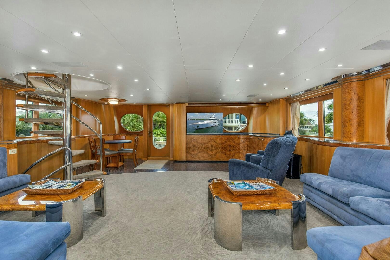 a living room with a blue couch aboard BOSS Yacht for Sale