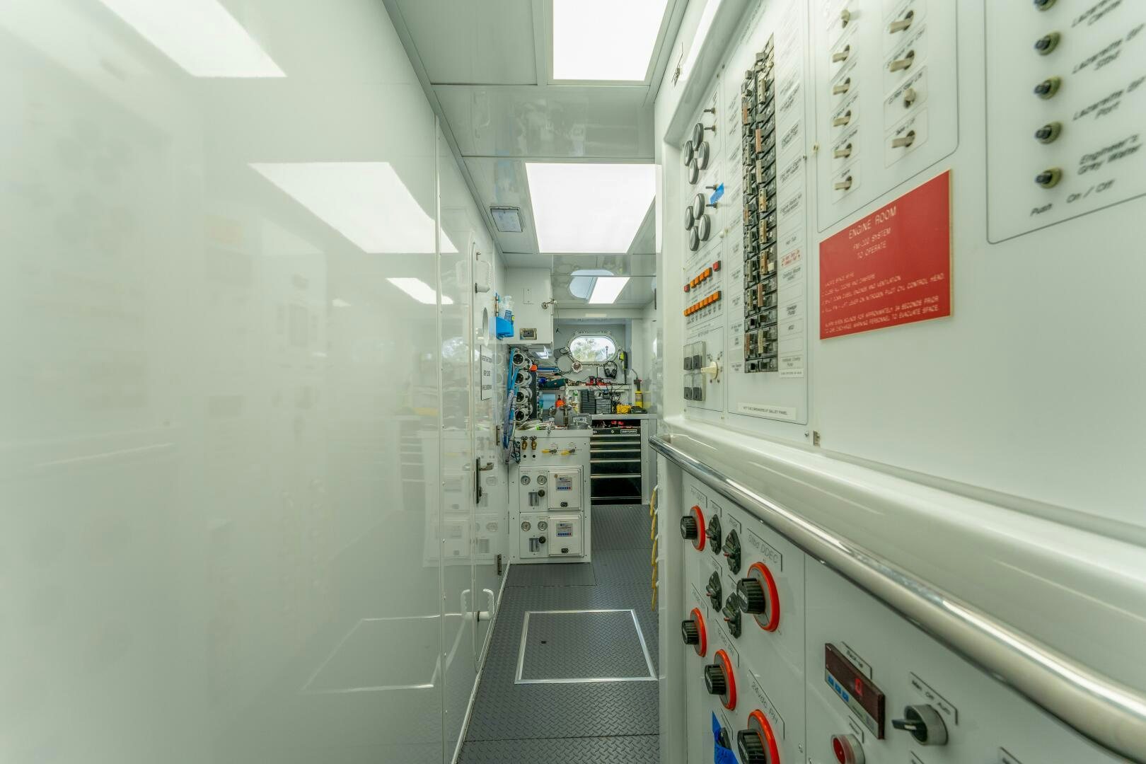 a hallway with white walls and red signs aboard RELENTLESS Yacht for Sale