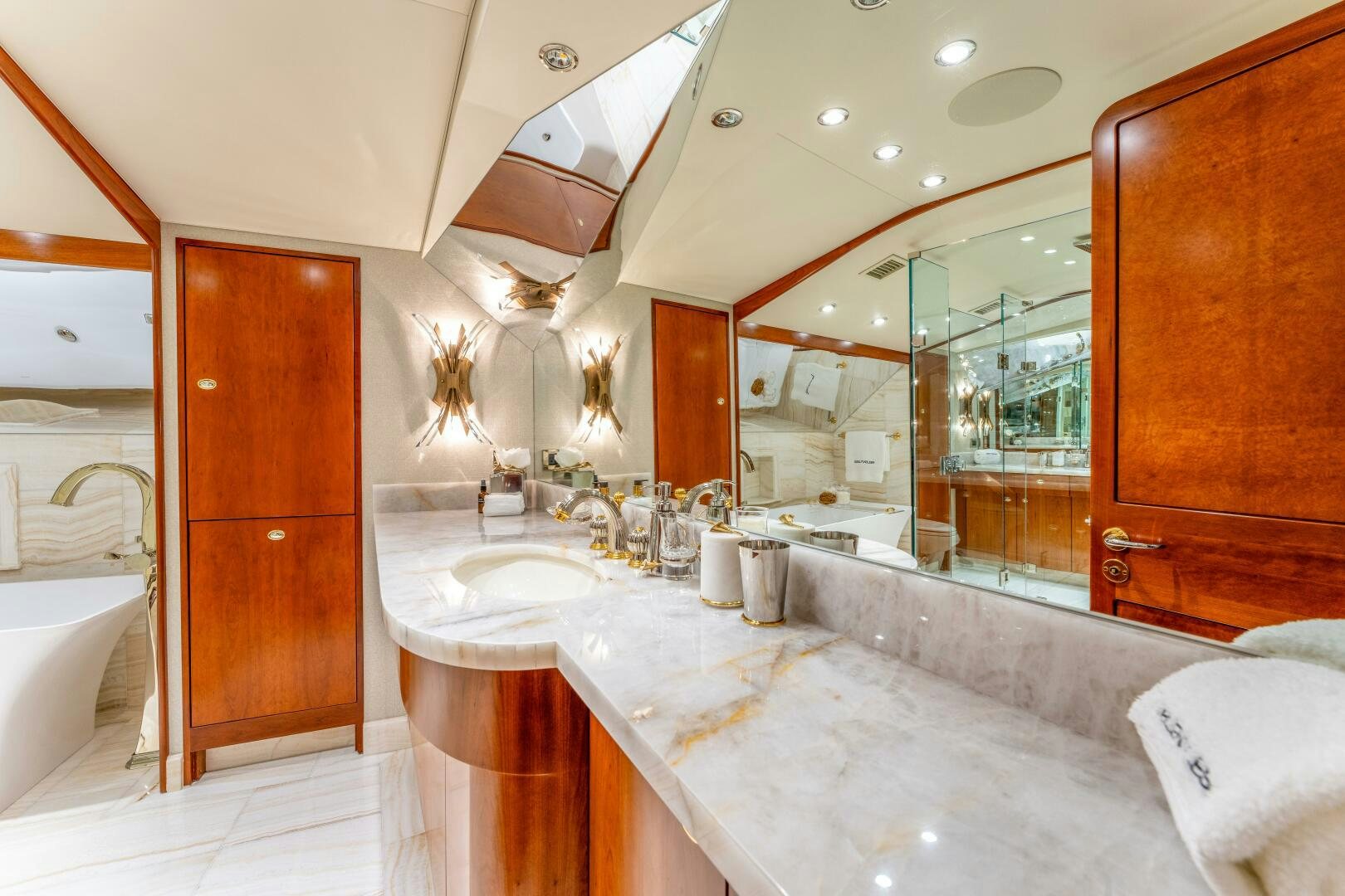 a bathroom with a large bathtub and sinks aboard RELENTLESS Yacht for Sale