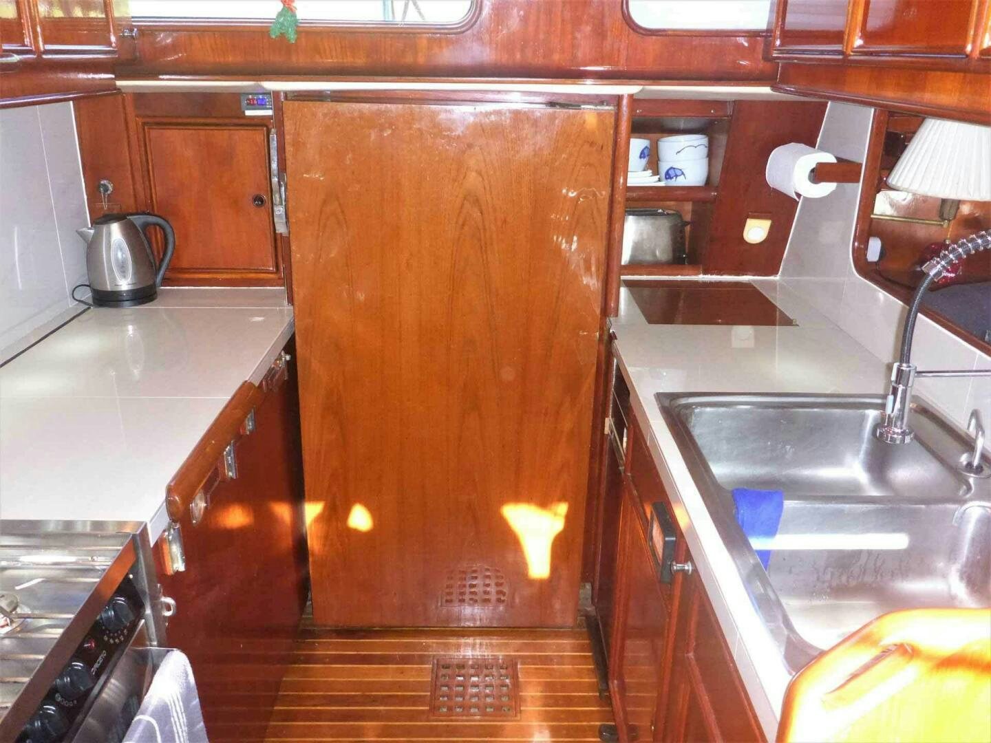 a kitchen with wooden cabinets aboard KOKOMO VI Yacht for Sale