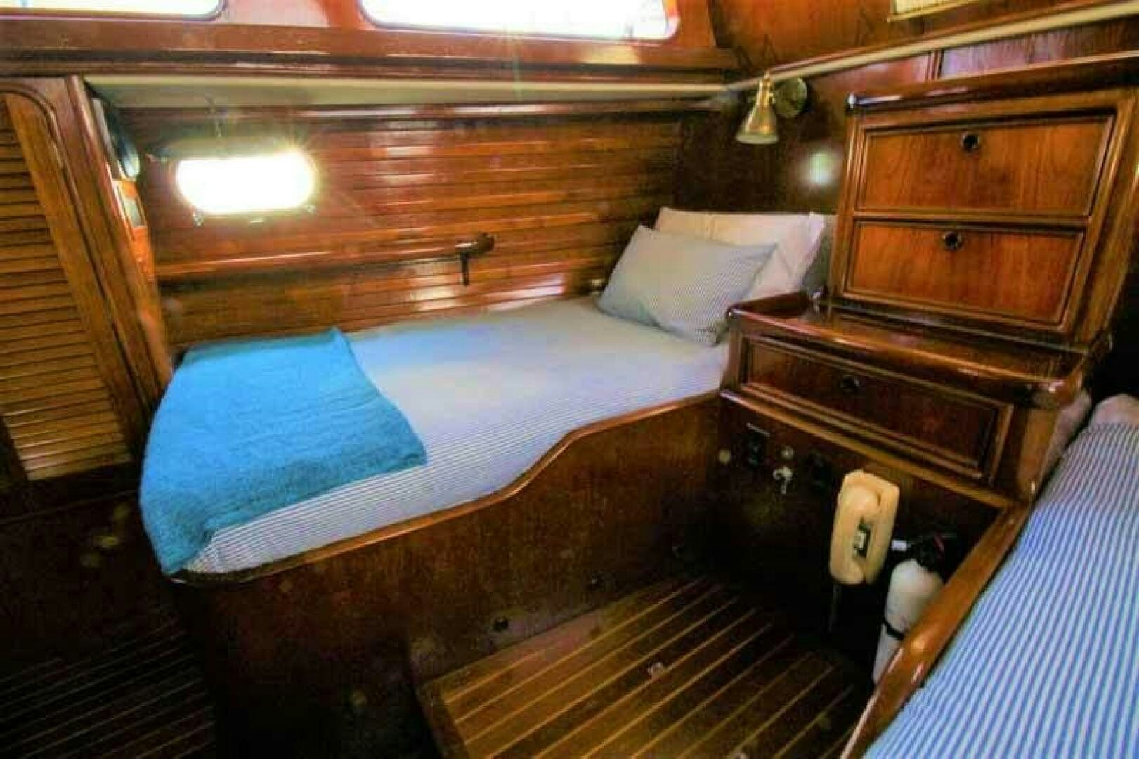 a bed with a wooden headboard aboard KOKOMO VI Yacht for Sale