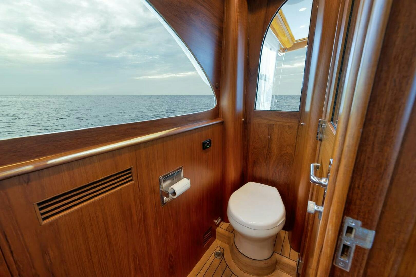 a bathroom with a toilet and a window aboard PERSISTENCE Yacht for Sale