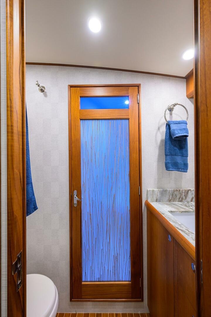 a bathroom with a blue shower door aboard PERSISTENCE Yacht for Sale