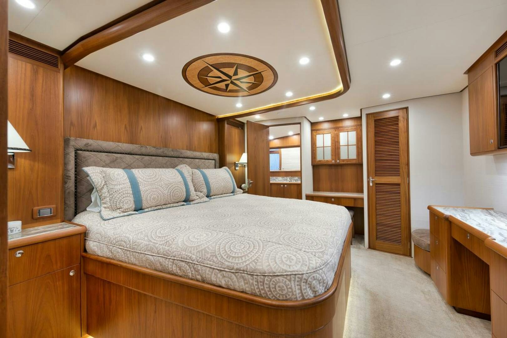 a bedroom with a bed and a wood door aboard PERSISTENCE Yacht for Sale