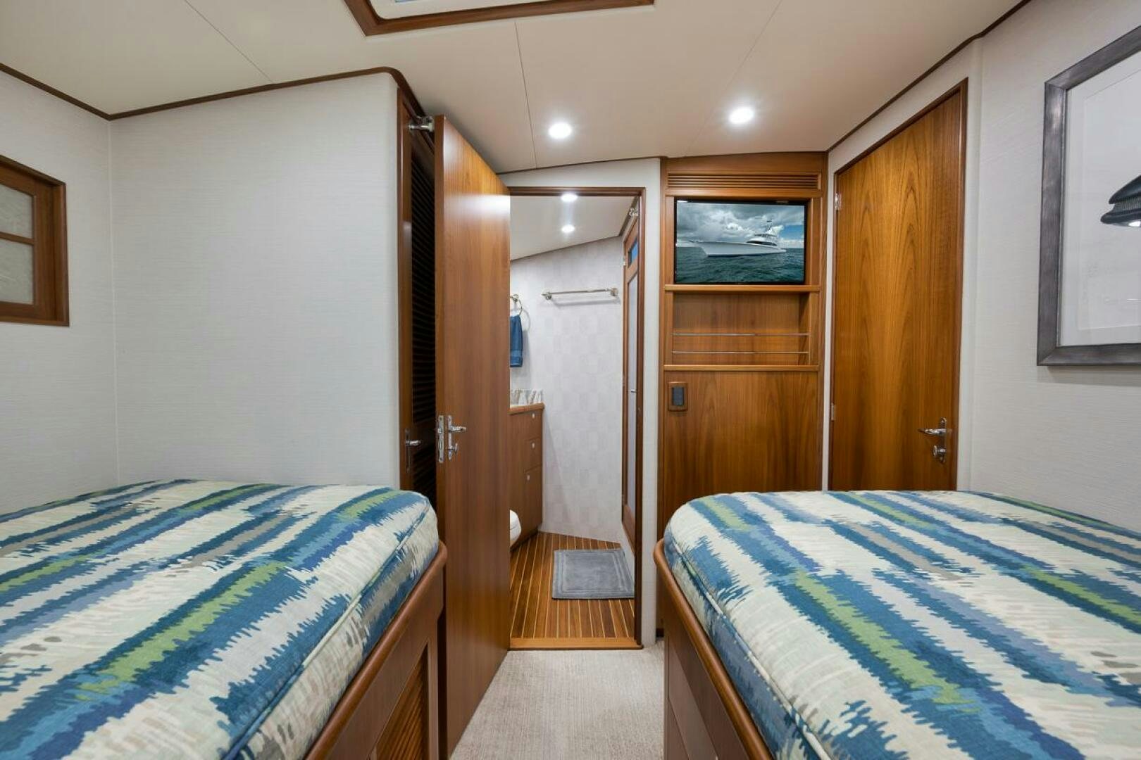 a bedroom with a couple of beds aboard PERSISTENCE Yacht for Sale