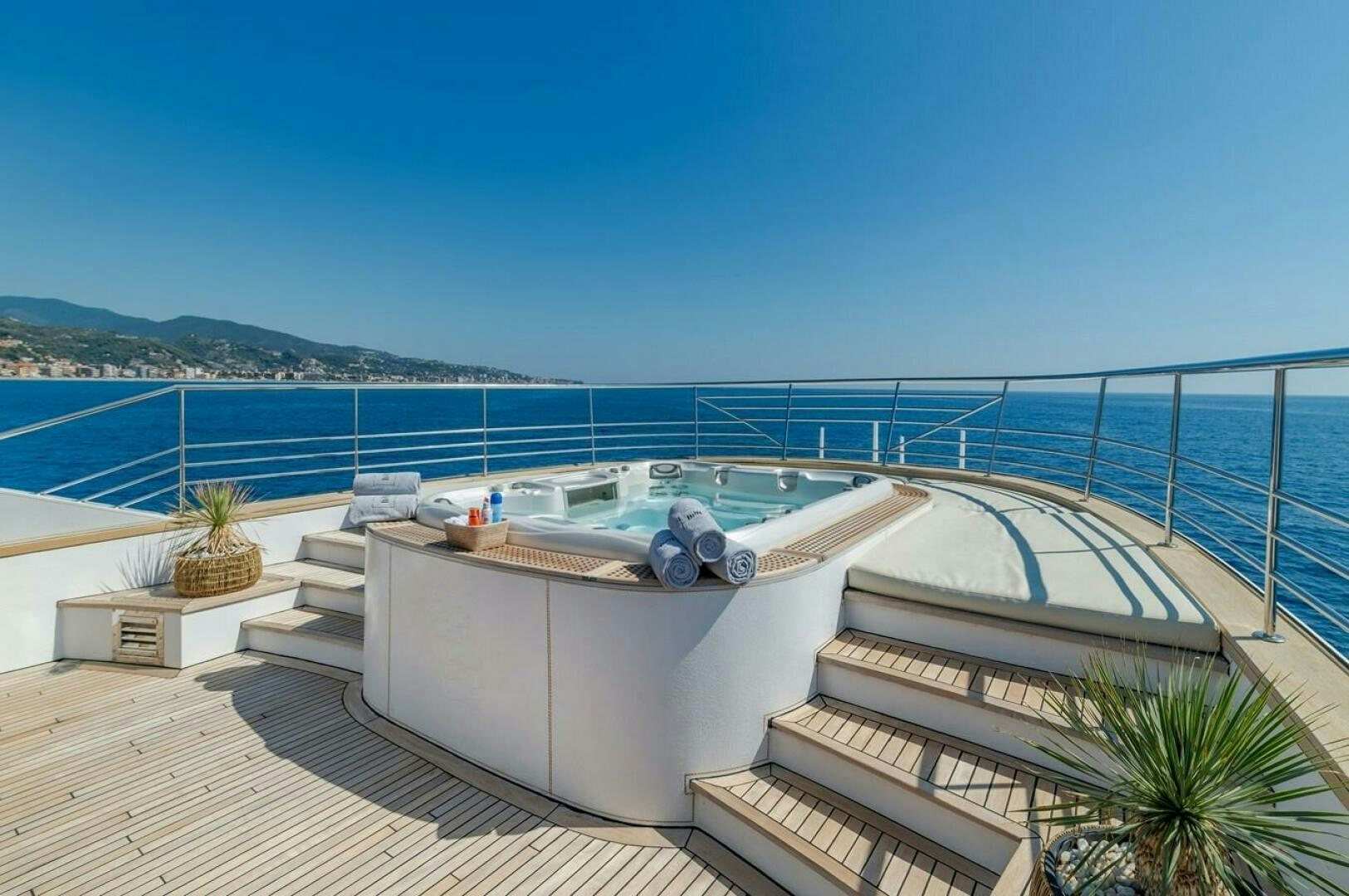 a deck with a pool and a view of the ocean aboard JOY ME Yacht for Sale