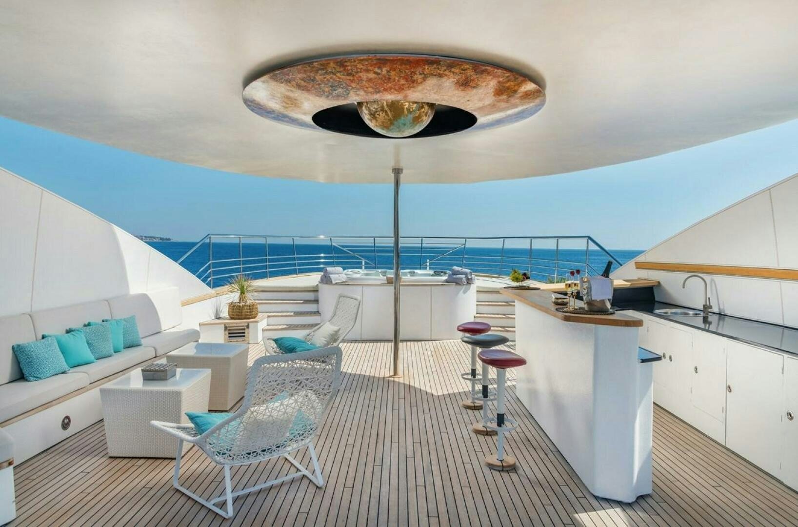 a room with a large white table and chairs and a large white and blue striped rug aboard JOY ME Yacht for Sale