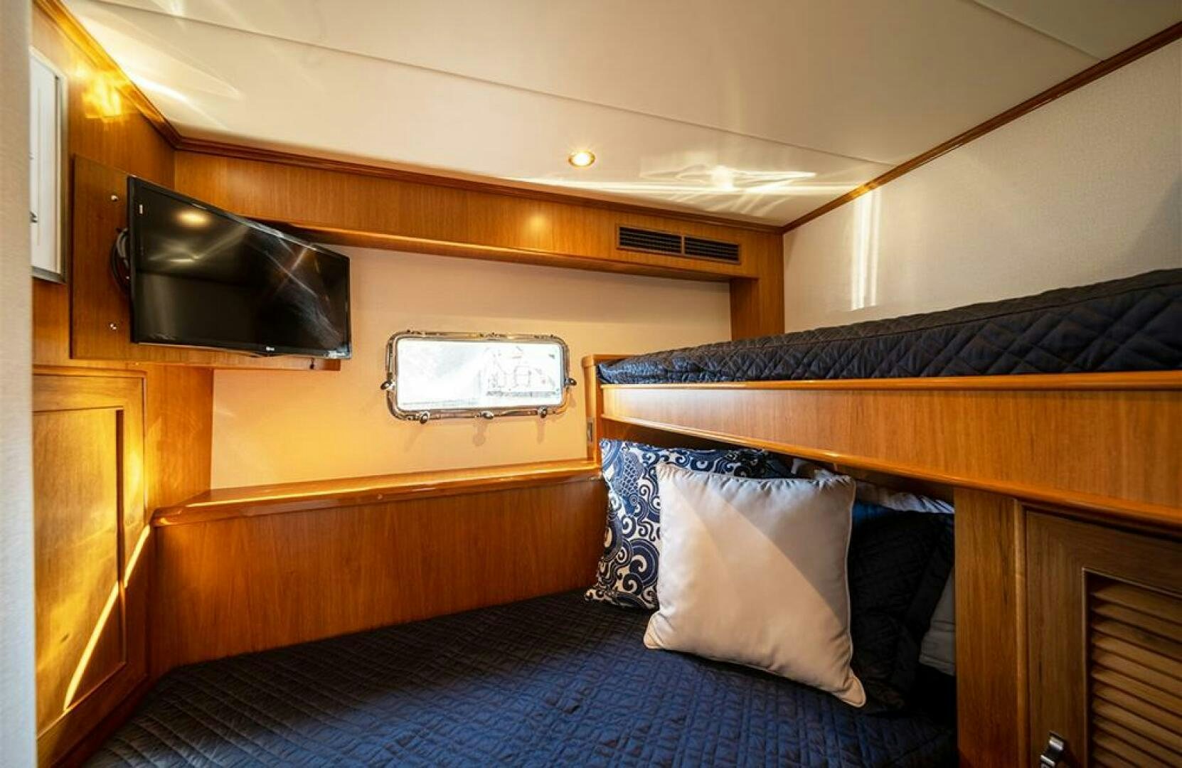 a bed with a television on the wall aboard JULIANNE Yacht for Sale