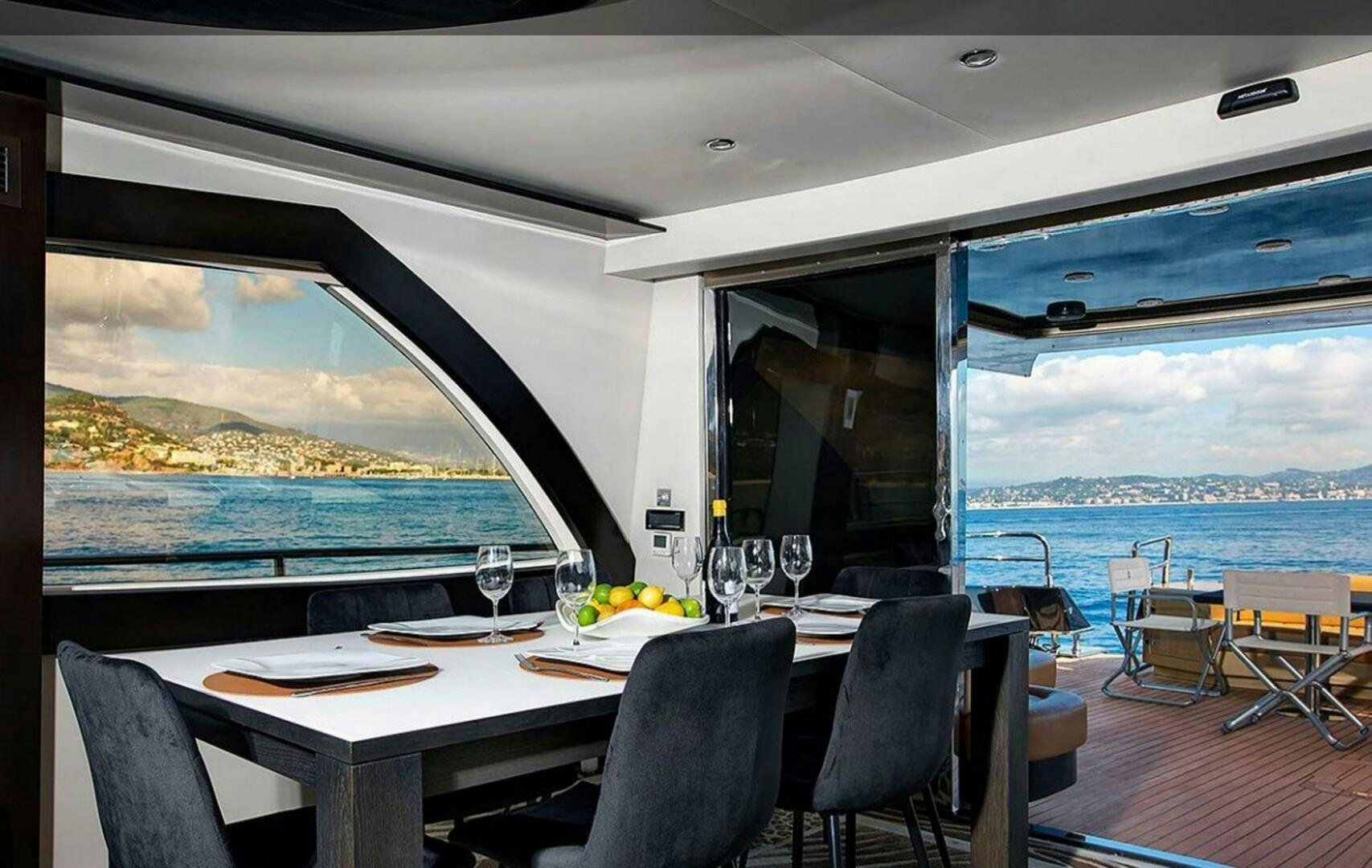 a table with glasses and a view of the ocean aboard CLAREMONT Yacht for Sale