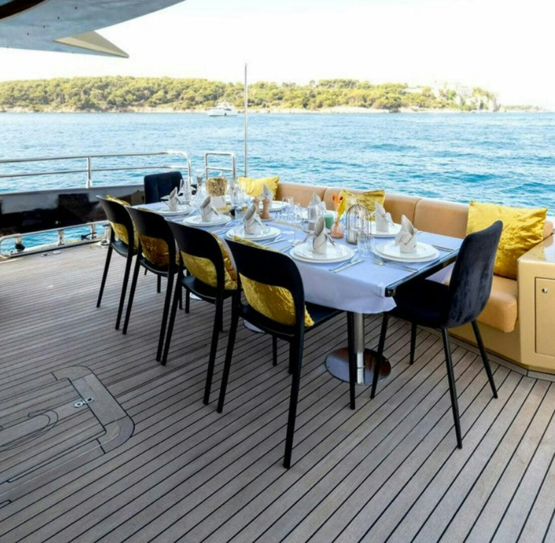 a table set for a meal on a deck overlooking a body of water aboard CLAREMONT Yacht for Sale