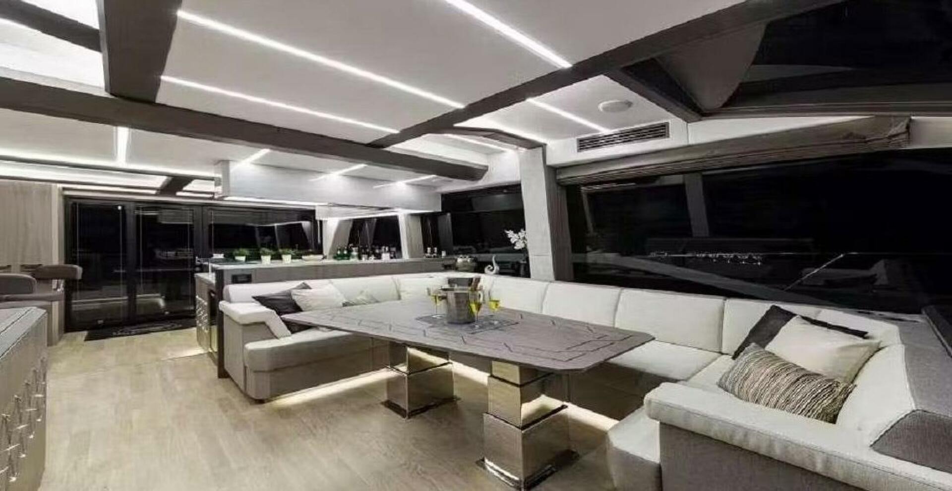 a large room with a table and couches aboard TRIPLE T Yacht for Sale