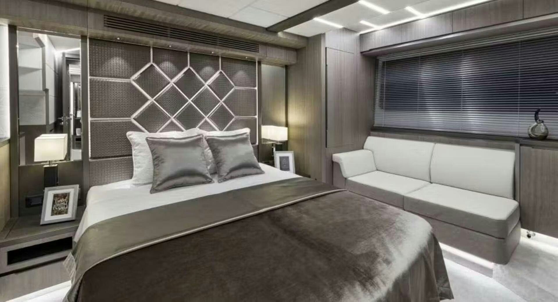 a room with a bed and a couch aboard TRIPLE T Yacht for Sale