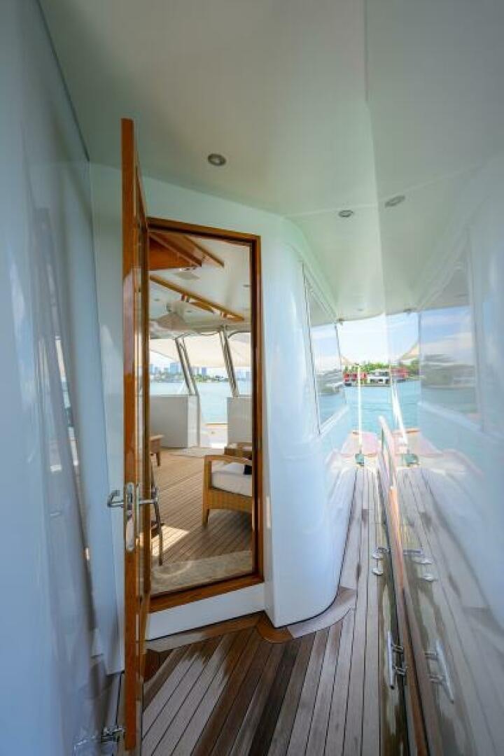 a wood deck with a view of a city through a glass door aboard ELECTRA Yacht for Sale
