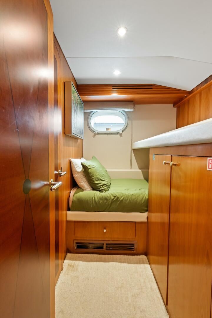 a bedroom with a bed and a closet aboard INEVITABLE Yacht for Sale