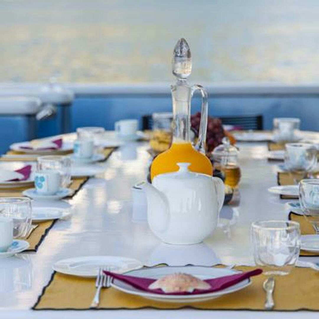 a table with plates and glasses aboard IRAMA Yacht for Sale