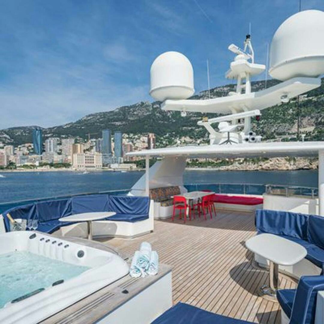 a deck with a deck and a view of a city and water aboard IRAMA Yacht for Sale