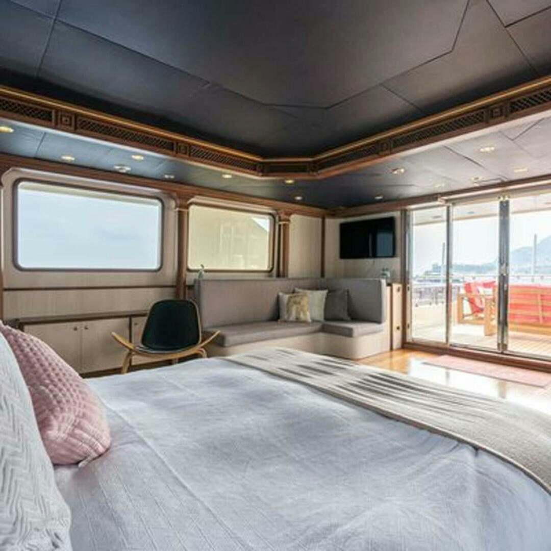 a bedroom with a bed and a chair aboard IRAMA Yacht for Sale