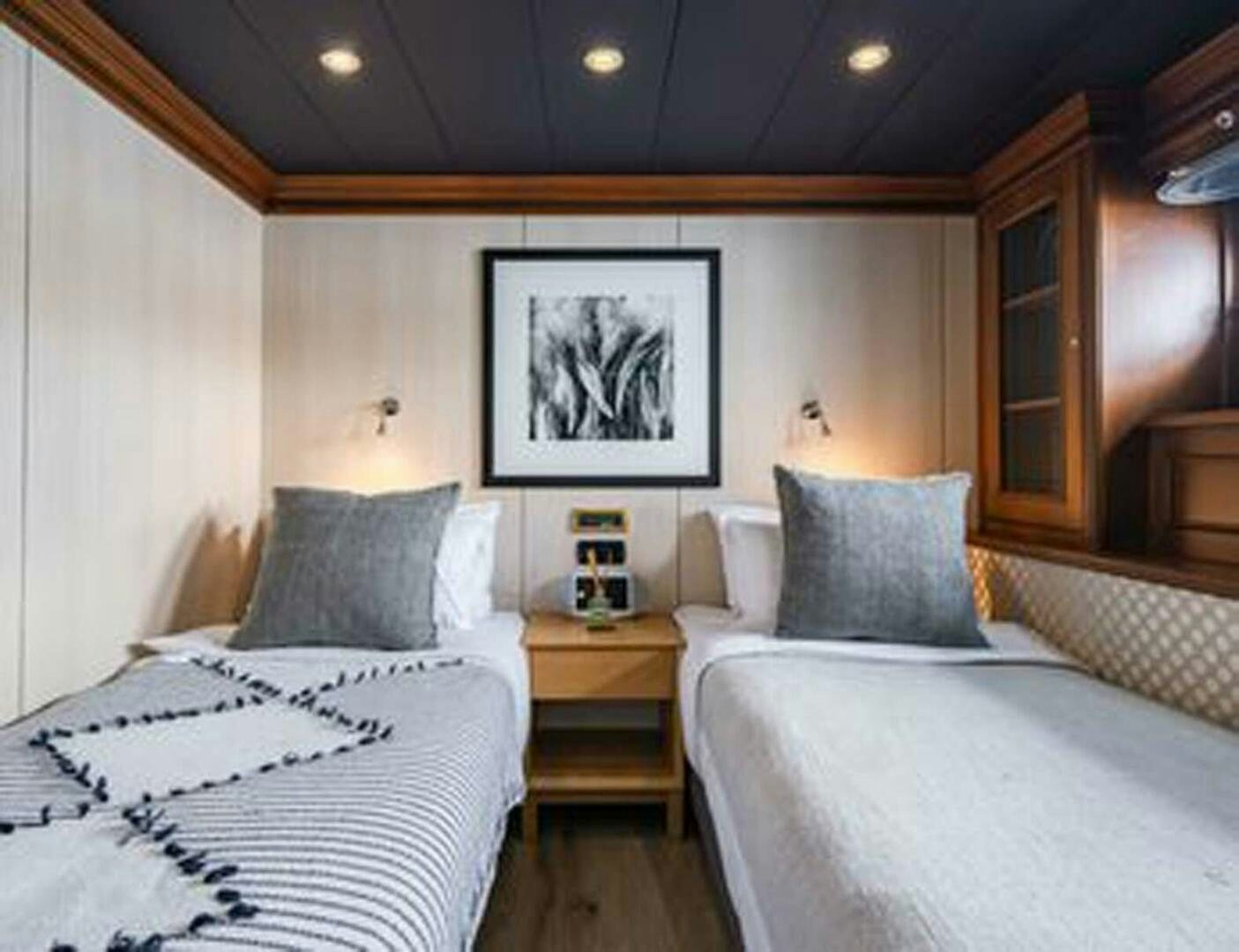 a bedroom with two beds aboard IRAMA Yacht for Sale