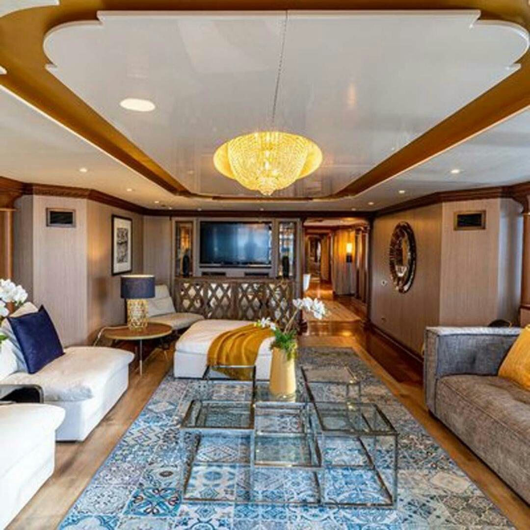 a living room with a large chandelier aboard IRAMA Yacht for Sale