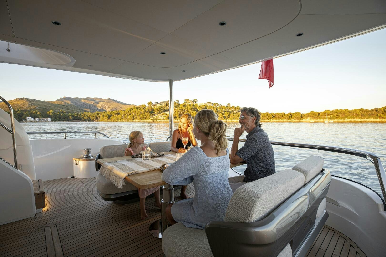 a group of people sitting around a table on a boat aboard PRINCESS Y80 Yacht for Sale