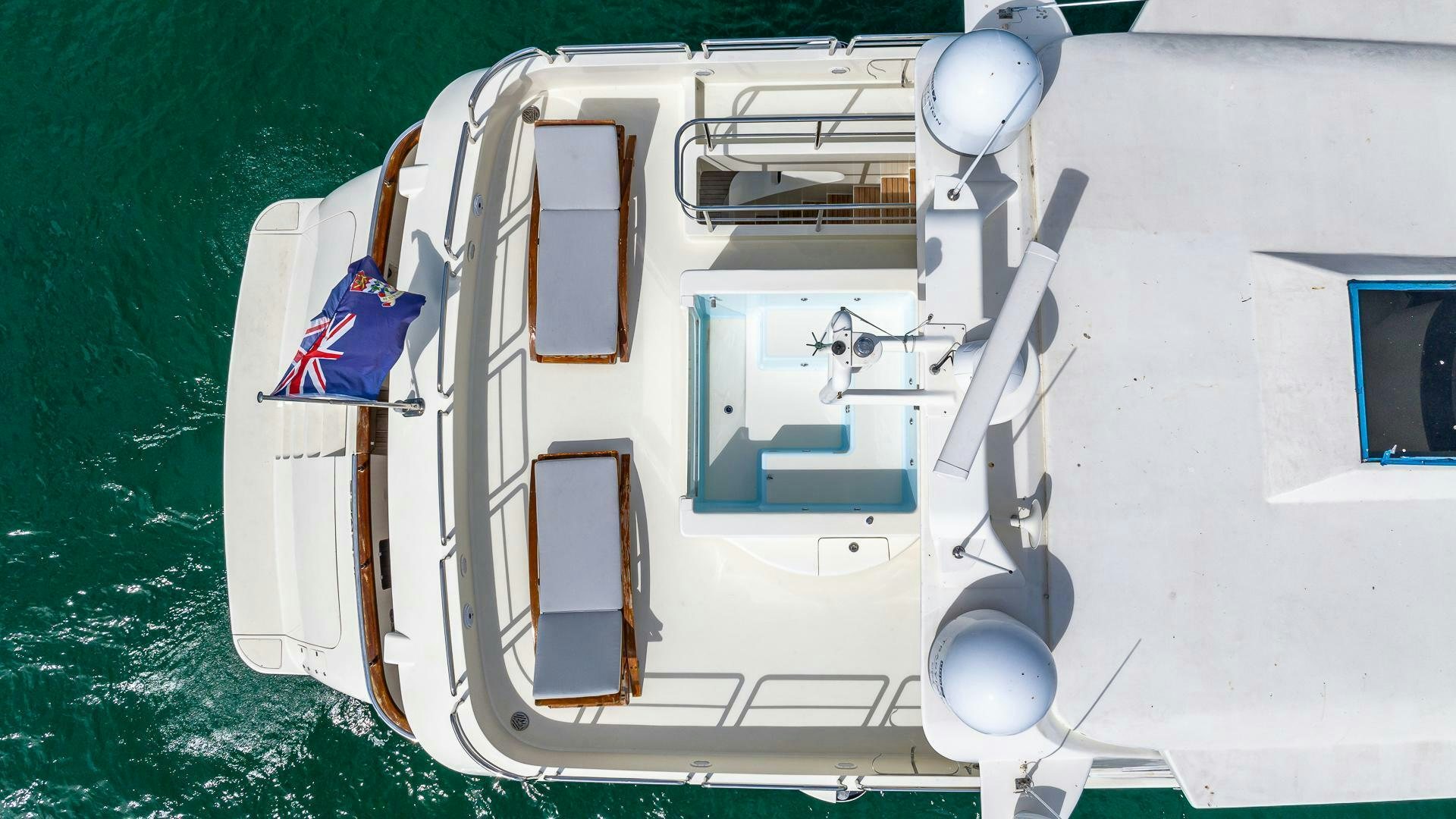 a white boat with a flag on it aboard 100 AZIMUT JUMBO Yacht for Sale
