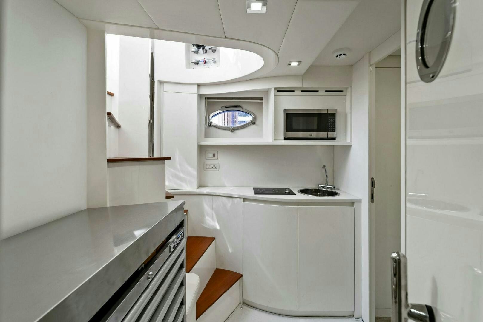 a small kitchen with white cabinets aboard G Yacht for Sale