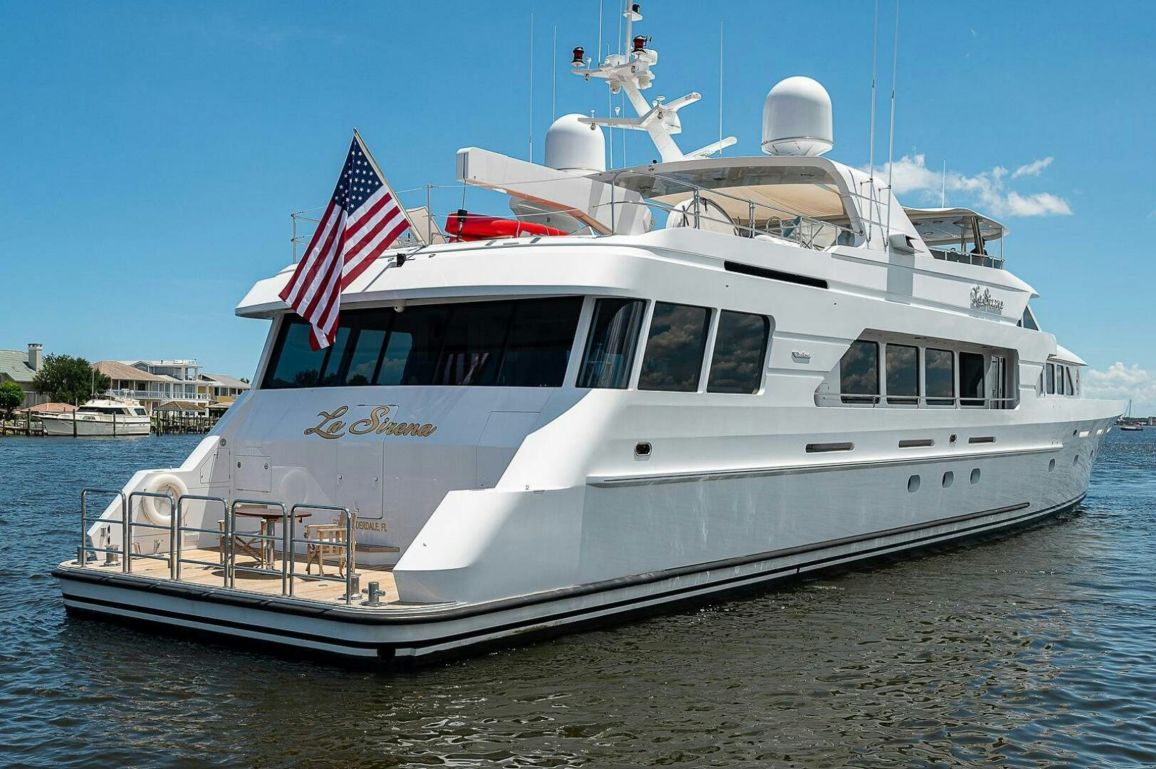 a large white boat with a flag on it aboard LA SIRENA Yacht for Sale