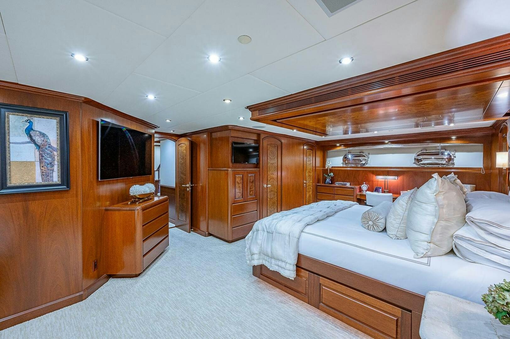 a bedroom with a bed and a wood cabinet aboard LA SIRENA Yacht for Sale