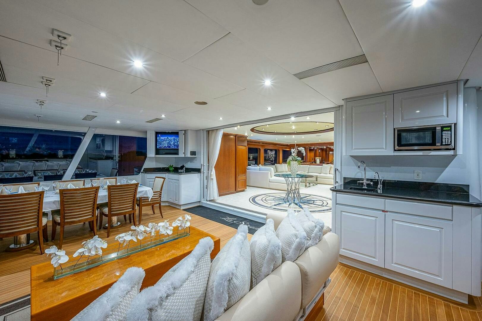 a living room with a kitchen and dining area aboard LA SIRENA Yacht for Sale