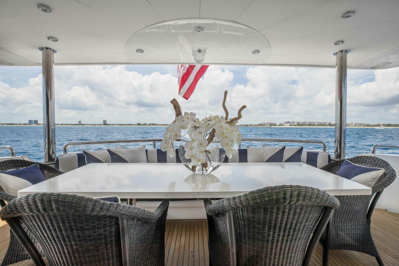 a table with chairs and a large body of water in the background aboard KENTUCKY BELLE Yacht for Sale