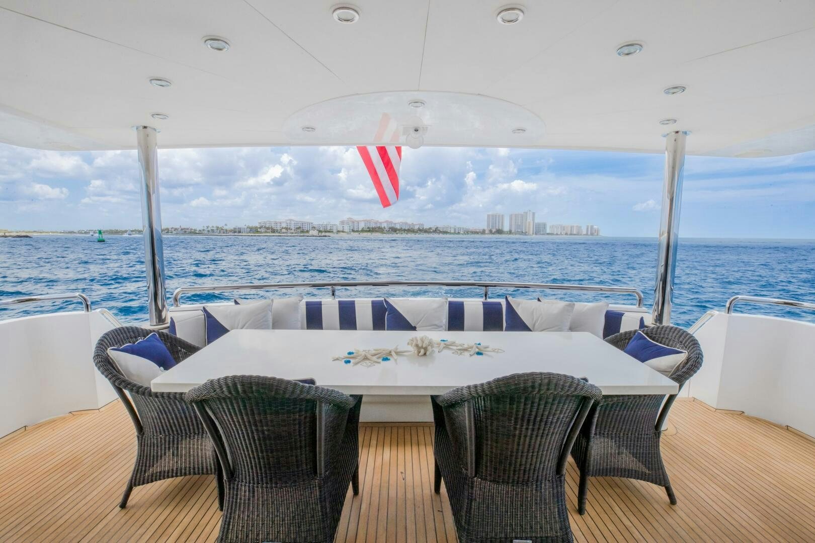 a table and chairs on a deck overlooking a large body of water aboard KENTUCKY BELLE Yacht for Sale
