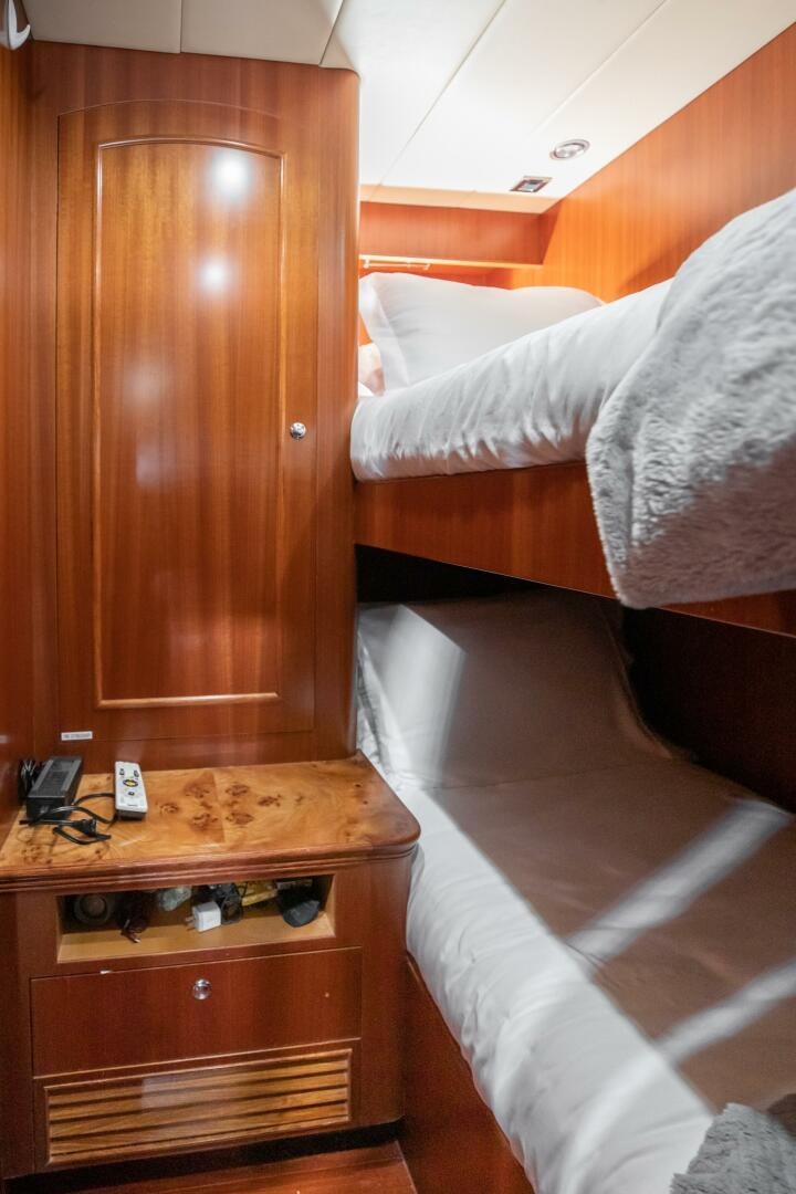 a bed with a wooden headboard aboard KENTUCKY BELLE Yacht for Sale