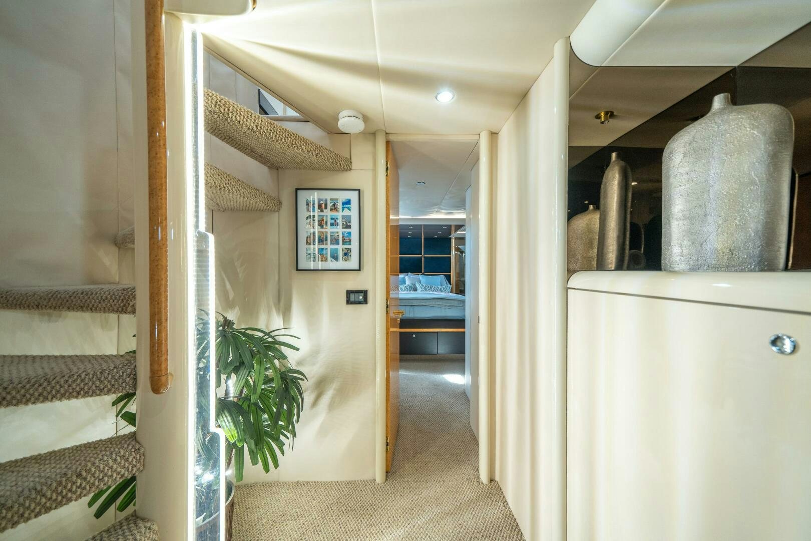 a hallway with a plant and a bed in it aboard PRESTIGE WORLDWIDE Yacht for Sale