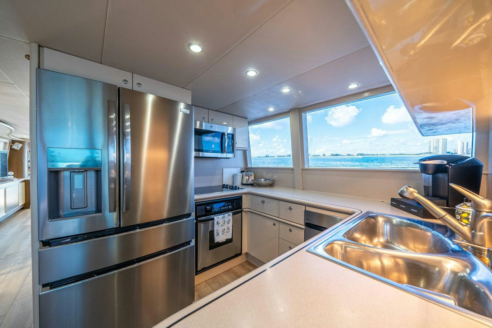 a kitchen with a stainless steel refrigerator aboard PRESTIGE WORLDWIDE Yacht for Sale
