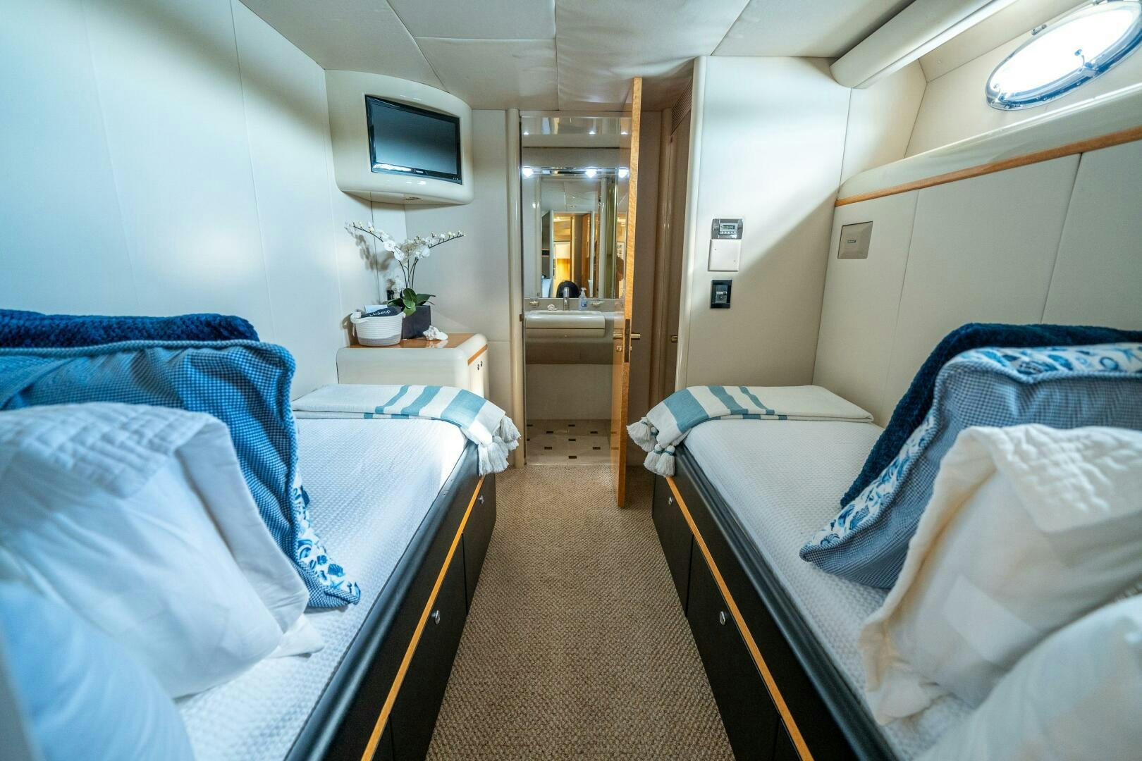 a room with beds and a tv aboard PRESTIGE WORLDWIDE Yacht for Sale