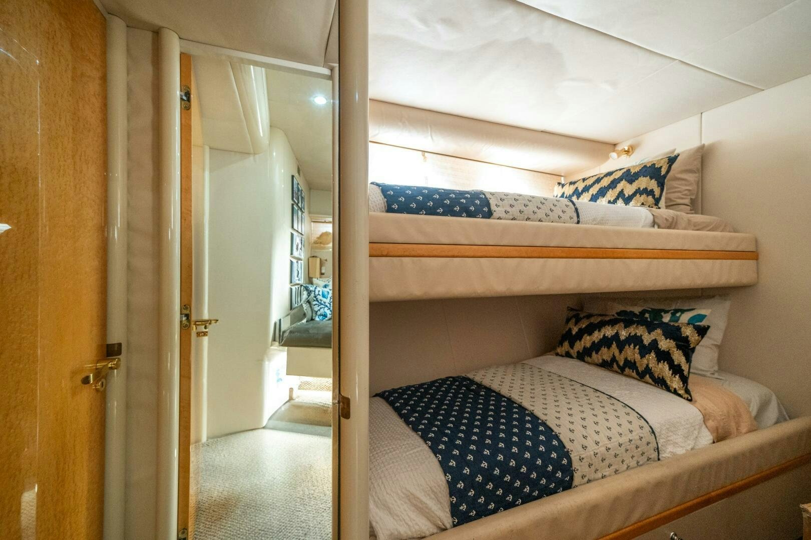 a bed with a blue and white pillow and a blue pillow on it aboard PRESTIGE WORLDWIDE Yacht for Sale