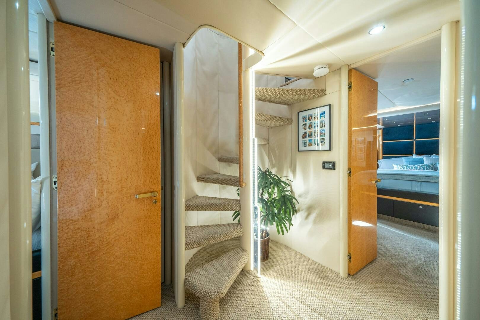 a hallway with a door and a plant in the middle aboard PRESTIGE WORLDWIDE Yacht for Sale