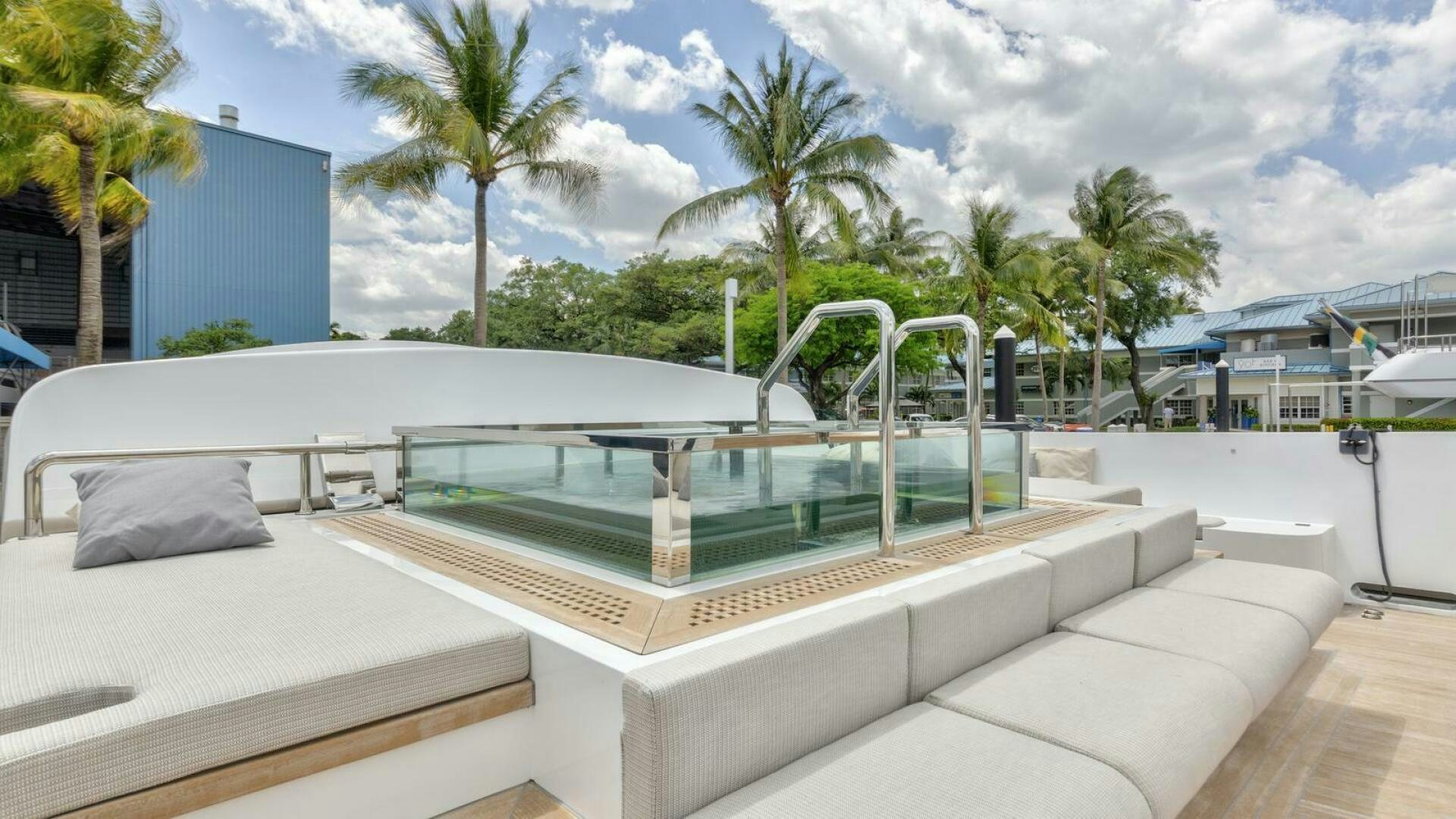 a large white pool with a deck and a deck with trees and buildings aboard OCEANIC 140 Yacht for Sale