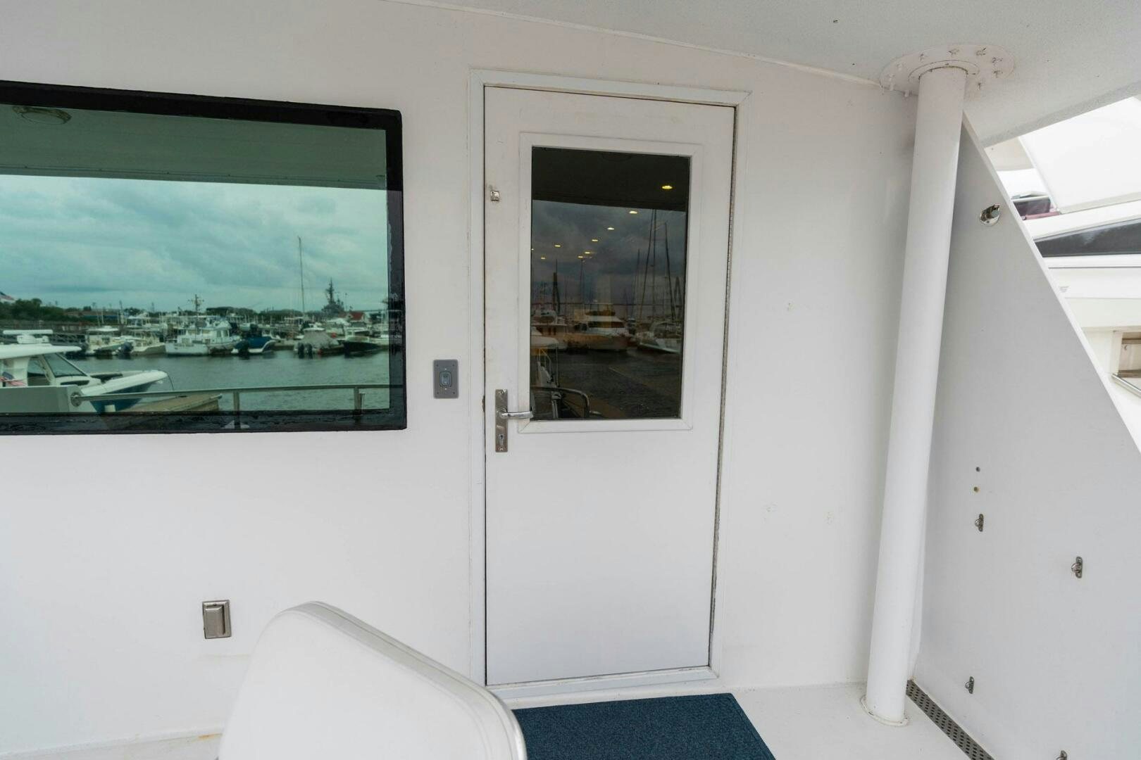 a room with a large window and a television on the wall aboard KRAKEN Yacht for Sale