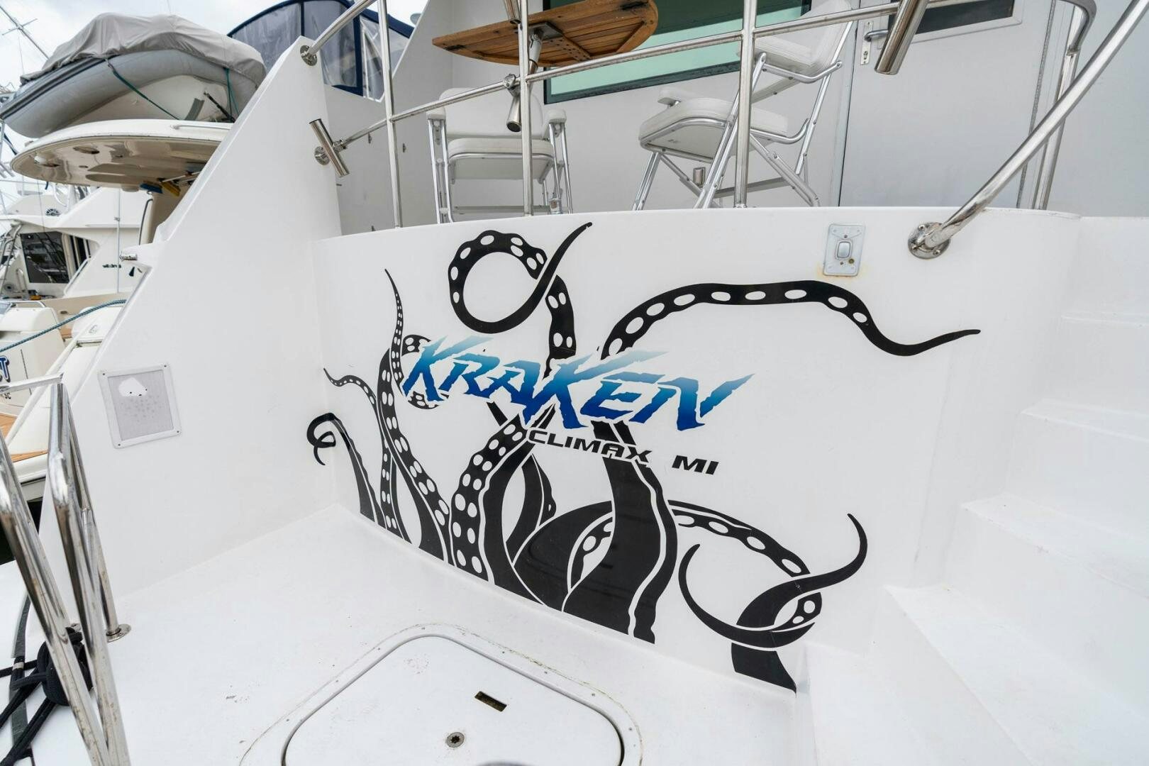 a white boat with black and blue graffiti on it aboard KRAKEN Yacht for Sale